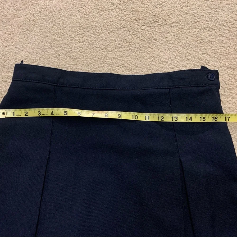 Navy blue pleated skirt with adjustable waist.